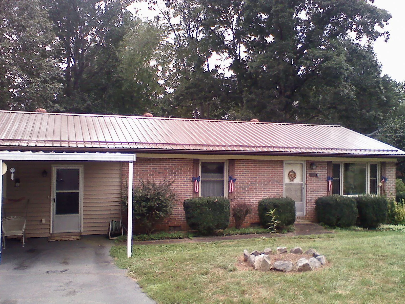Bronze metal roof and carport on a brick ranch home — Roof Repair work by our crew in Boulder